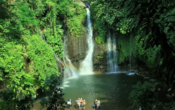 Curug Sibedil waterfall surrounded by green forest